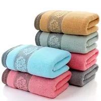 Pilha de toalhas em castanho-claro, verde-sálvia, azul, rosa e cinzento, com barras com desenho