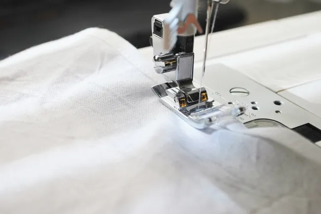 Sewing machine hemming white terry fabric