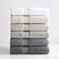 Pila de seis toallas de baño dobladas, en degradado del blanco al gris antracita, cada una con cenefa acanalada