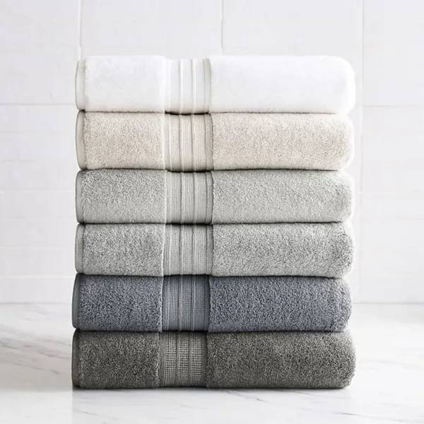 Pila di sei asciugamani da bagno piegati, in sfumatura dal bianco al grigio fino all'antracite, ciascuno con balza operata a coste