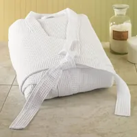 Albornoz blanco de nido de abeja doblado sobre un suelo de baldosas